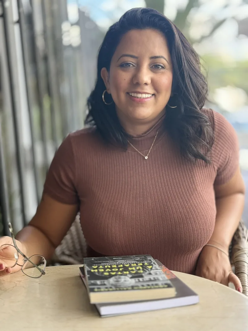 Deise Cerqueira, Psicóloga Clínica com livros na mesa